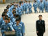 Prisoners walk beside a police escort du